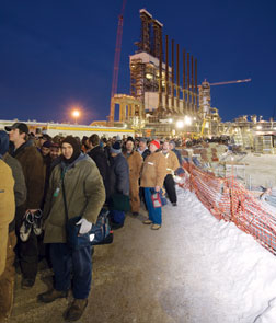 Workers queue up after day of construction. The median age of construction workers in the oil-sands region is 50 years.