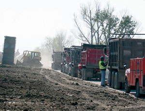 Borrow trucks line up to support construction on a New Orleans levee.