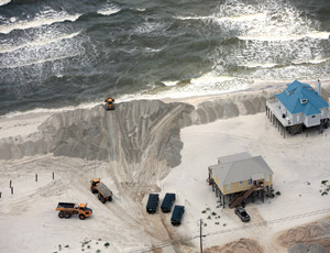 ON THE FRONTLINE Crews mobilize heavy equipment to build oil-blocking berms on Dauphin Island, Ala.